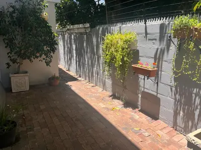a brick walkway with potted plants on a wall at Secluded Silver Mile with solar back-up in Cape Town