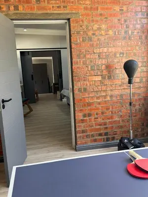 a room with a brick wall and a table with a lamp at Alicante self-catering 2 Bedroom apartment sleeps 4 in Worcester