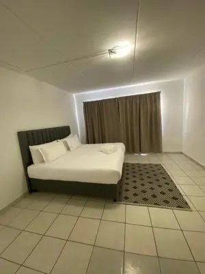 a white bed in a room with a window at Eversham Boutique in Cape Town