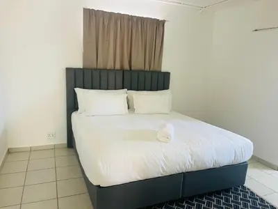 a bed with a black headboard in a room at Eversham Boutique in Cape Town