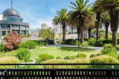 a park with palm trees and a building at Palmcrest Eden in Cape Town