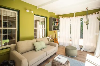 a living room with green walls and a couch at Onrus Sunshine Beach Days in Hermanus