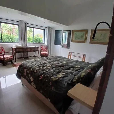 a bedroom with a king sized bed and a table at Awesome cottage, stone throw from cliff path, golf, restaurant in Hermanus