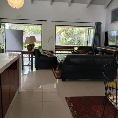 a living room with two couches and a table at Awesome cottage, stone throw from cliff path, golf, restaurant in Hermanus