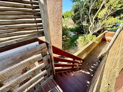 a wooden bench sitting on top of a balcony at Egret's Lookout in Cape Town