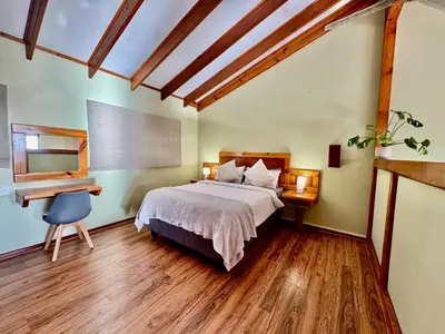 a bedroom with a bed and a desk and a desk at Egret's Lookout in Cape Town