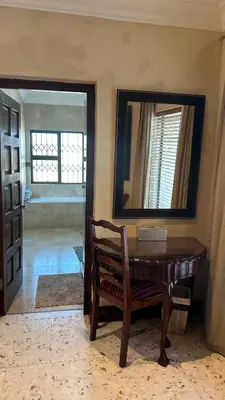 a mirror and a wooden table in a room at Clements Apartment in Avondale