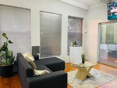 a living room with a couch and a table at claremont guesthouse in Cape Town