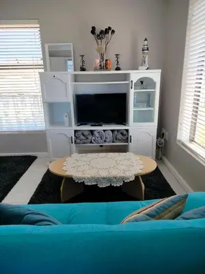 a living room with a blue couch and a tv at Take A Break in Bettyʼs Bay