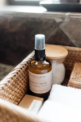 a bottle of essential oil in a basket with a toilet at Whale Away Guest House in Hermanus