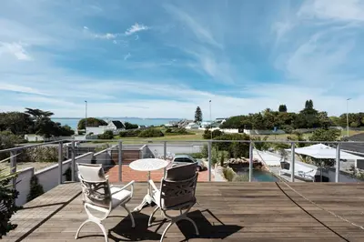 a patio with two chairs and a table on a deck at Whale Away Guest House in Hermanus