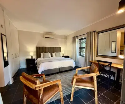 a bedroom with a bed and a desk and a desk at 1 at Huis Piron in Stellenbosch
