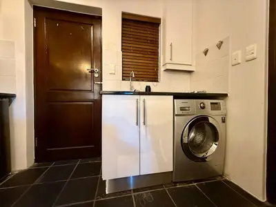 a kitchen with a washing machine and a door at 1 at Huis Piron in Stellenbosch