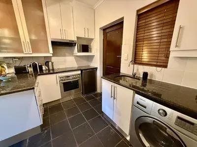 a kitchen with a washer and a washing machine at 1 at Huis Piron in Stellenbosch