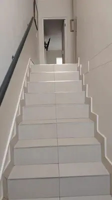 a stairway with white stairs in a house at Tin Home 88 in Cape Town