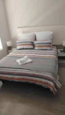 a bed with a pair of white shoes on it at Tin Home 88 in Cape Town