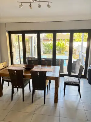 a dining room with a wooden table and chairs at Christal Villa A33 in Cape Town