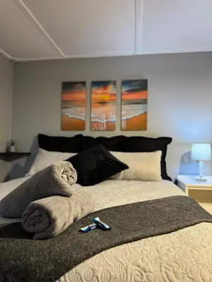 a bed with a towel on it with three paintings at Worcester Cozy Stay - Apto 2 in Worcester