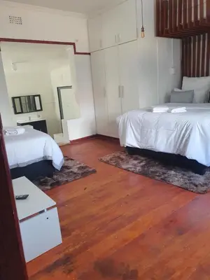 a hotel room with two beds and a mirror at Ludinz Accomodation Self Catering in Avondale