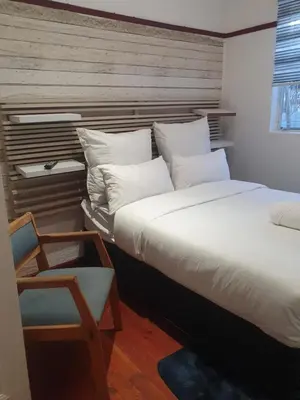 a pair of beds in a room with a chair at Ludinz Accomodation Self Catering in Avondale