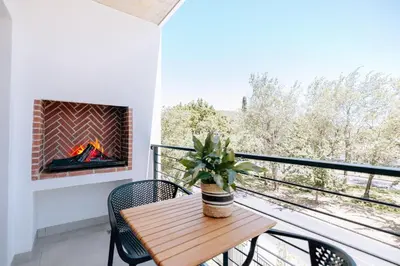a balcony with a table and a fireplace at 10 at The Alxndr - Stellenbosch Central in Stellenbosch