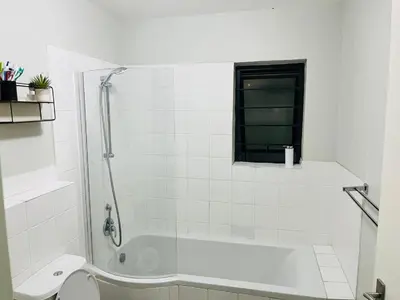 a white bathroom with a shower and a toilet at Valley Escape in Cape Town