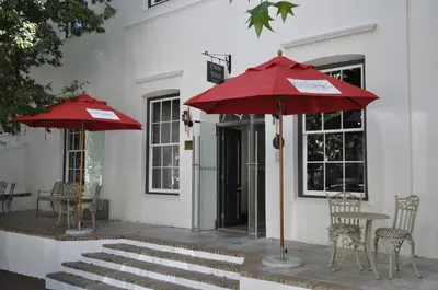 two red umbrellas in front of a building at Oude Werf Hotel in Stellenbosch