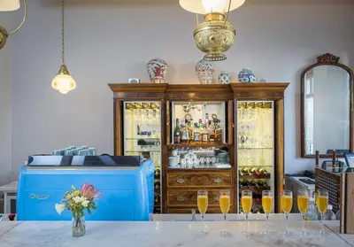 a room with a wooden cabinet with glasses of wine at Oude Werf Hotel in Stellenbosch