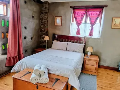 a bedroom with a bed with towels on a table at Serene, cosy stay with a mountain view in Greyton