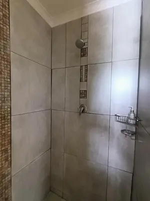 a bathroom with a shower with a glass door at Serene, cosy stay with a mountain view in Greyton