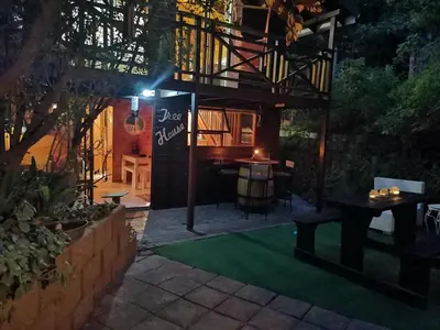 a house with a deck with a table and a table at Log Cabin- Forest, Lagoon Sea location in Hermanus