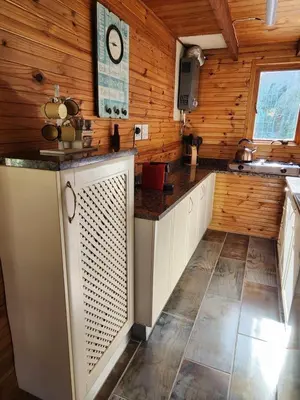a kitchen with wooden walls and a counter at Log Cabin- Forest, Lagoon Sea location in Hermanus