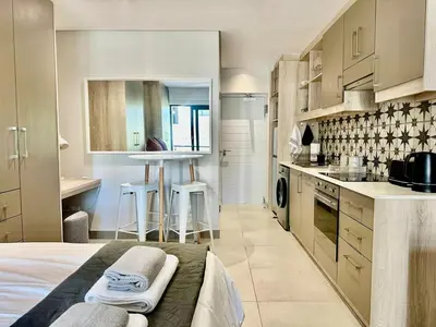a kitchen with a bed and a table in a room at 22 at The Den in Stellenbosch