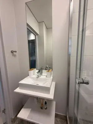 a white bathroom with a sink and a shower at 22 at The Den in Stellenbosch
