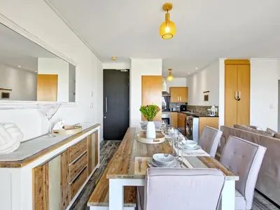a kitchen and dining room with a table and chairs at Sea, Canal & Mountain View, Rooftop Jacuzzi & BBQ in Cape Town