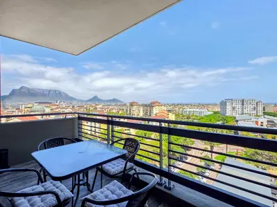 a table and chairs on a balcony with a view at Sea, Canal & Mountain View, Rooftop Jacuzzi & BBQ in Cape Town