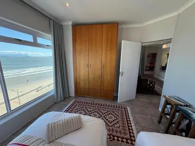 a bedroom with a bed and a view of the beach at Pips Place Penthouse 501 in Strand