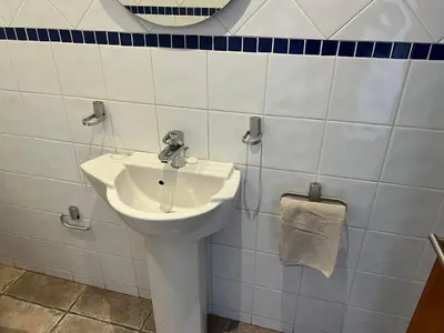 a white bathroom with a sink and a towel at Pips Place Penthouse 501 in Strand