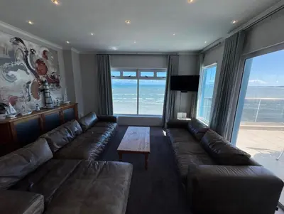 a living room with a leather couch and a table at Pips Place Penthouse 501 in Strand