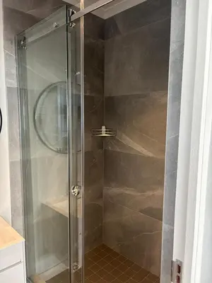 a shower with a glass door in a bathroom at 37A Modern Apartment quiet suburb mountain views in Stellenbosch