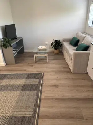 a living room with a couch and a table at 37A Modern Apartment quiet suburb mountain views in Stellenbosch