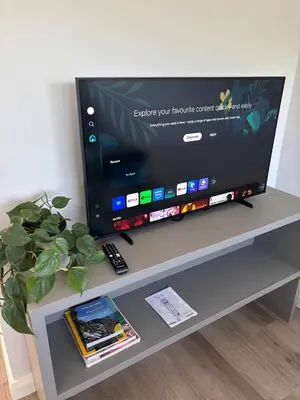 a flat screen tv sitting on top of a table at 37A Modern Apartment quiet suburb mountain views in Stellenbosch