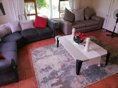 a living room with couches and a coffee table at Mimosa House Double Room in Brackenfell