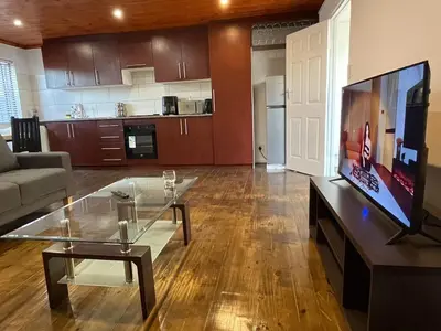 a living room with a couch and a glass table at AAA Luxury Homes Goodwood Cpt in Elsiesrivier