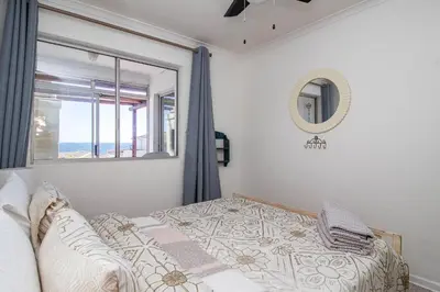 a bedroom with a bed and a window at Nostalgie - Hermanus Beach Club in Hermanus