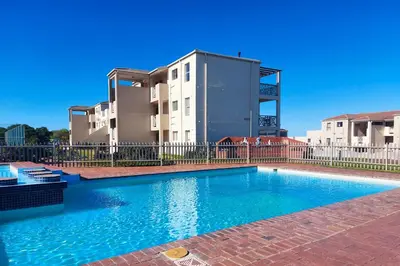 a swimming pool in front of a building at Nostalgie - Hermanus Beach Club in Hermanus