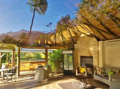 a patio with a fireplace and a table and chairs at Val d'Or Estate in Franschhoek