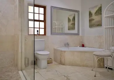 a bathroom with a tub and a toilet and a sink at Val d'Or Estate in Franschhoek