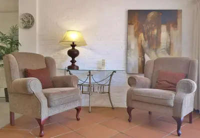 two chairs and a table in a living room at Val d'Or Estate in Franschhoek