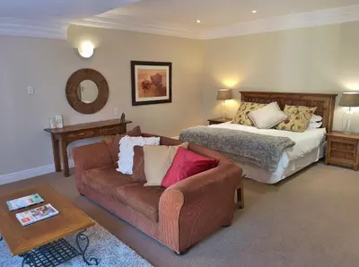 a living room with a couch and a bed at Val d'Or Estate in Franschhoek